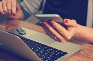 woman at laptop with iphone