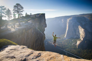 man walking tightrope across canyon