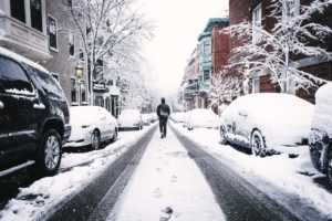 man walking down snowy street
